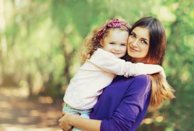 Mutlu genç anne ve açık havada pa içinde şirin çocuk portresi