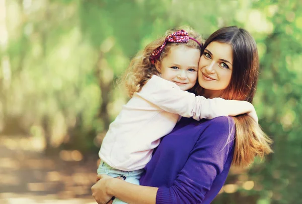 Portrait de heureuse jeune mère et mignon enfant en plein air dans le pa — Photo