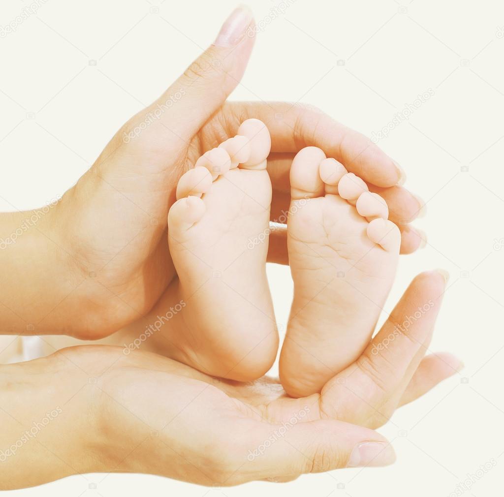 Baby feet in hands mother