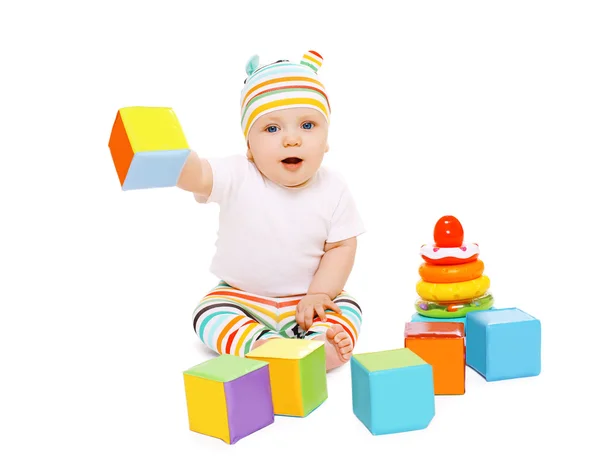 Bébé drôle en chapeau rayé jouant avec des jouets colorés — Photo