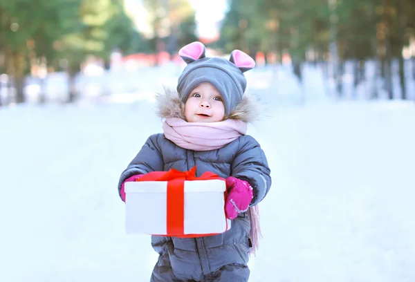 Child with gift box outdoors in winter day — Stock Photo, Image