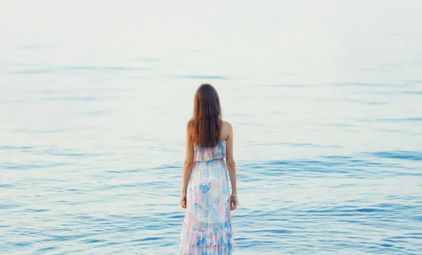 Bela jovem mulher de pé perto do mar, de volta feminino em resumo — Fotografia de Stock