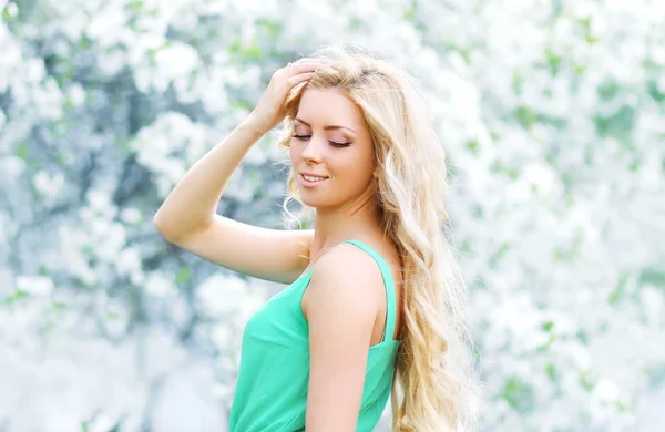 Spring portrait of beautiful young woman enjoying in a flowering — Stock Photo, Image