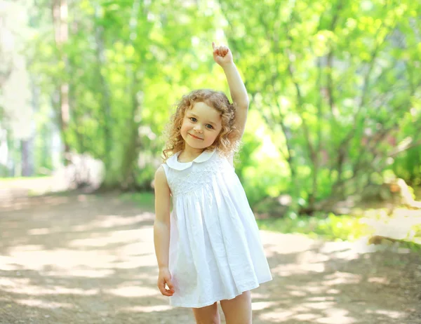 Lilla barnet promenader i parken och visar upp hand, soliga summ — Stockfoto