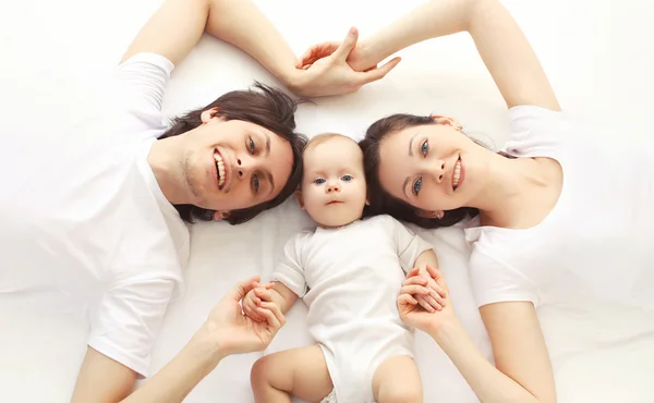 Nahaufnahme Porträt einer glücklichen Familie zusammen auf dem Bett liegend bei ho — Stockfoto