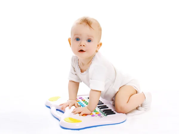 Retrato de bebê curioso brincando com piano de brinquedo — Fotografia de Stock