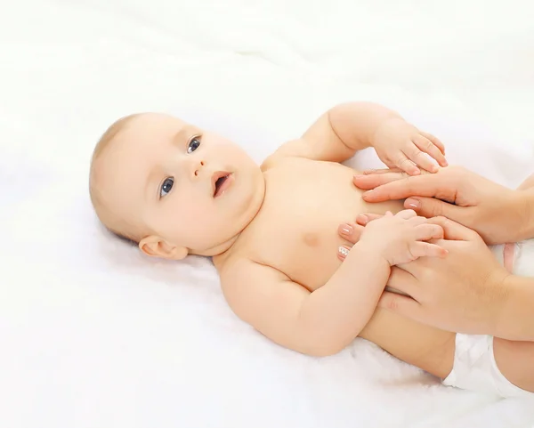 Baby massage lying on the back at home on the bed — Stock Photo, Image