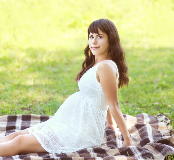 Güzel hamile genç kadın yaz günde çim üzerinde yalan — Stok fotoğraf