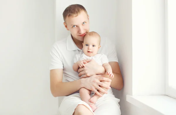 Батько і дитина вдома в білій кімнаті, що сидить біля вікна — стокове фото