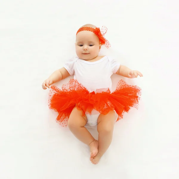 Linda niña pequeña acostada en la falda roja, vista superior —  Fotos de Stock