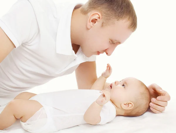 Feliz padre joven con su bebé en la cama en casa —  Fotos de Stock