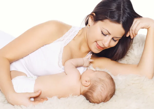 Feliz madre sonriente y el bebé acostado en la cama en casa, la familia c —  Fotos de Stock