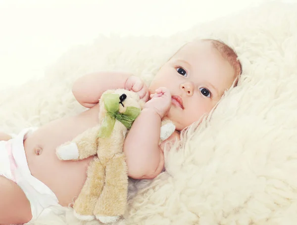 Little baby with teddy bear lying on the bed — Stock Photo, Image