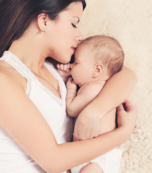 Mom and baby sleeping on the bed, top view. Gentle, warm feeling