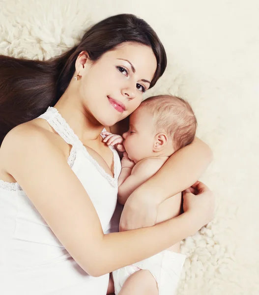 Porträt einer jungen Mutter mit schlafendem Baby auf dem Bett, Draufsicht — Stockfoto