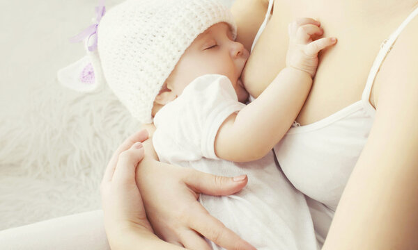 Soft photo mother feeding breast her baby at home 