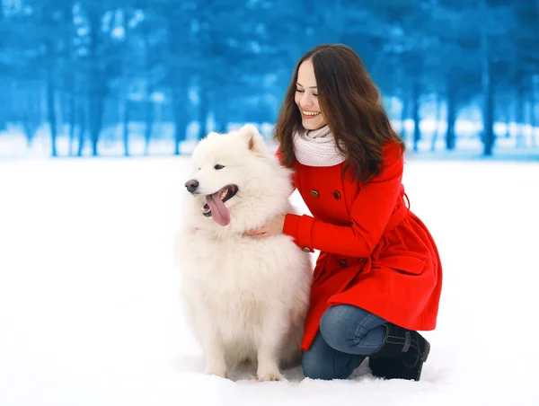 Happy woman having fun with white Samoyed dog outdoors in winter — Stock Photo, Image