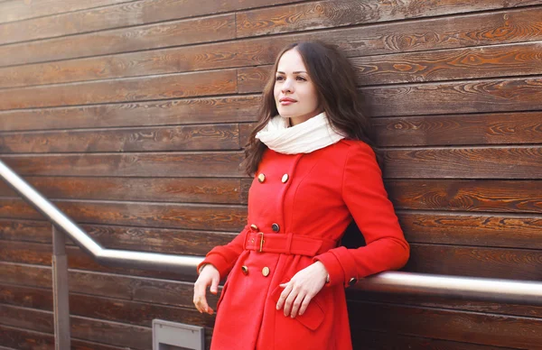 Retrato de mulher bonita em casaco vermelho em contra uma wa de madeira — Fotografia de Stock