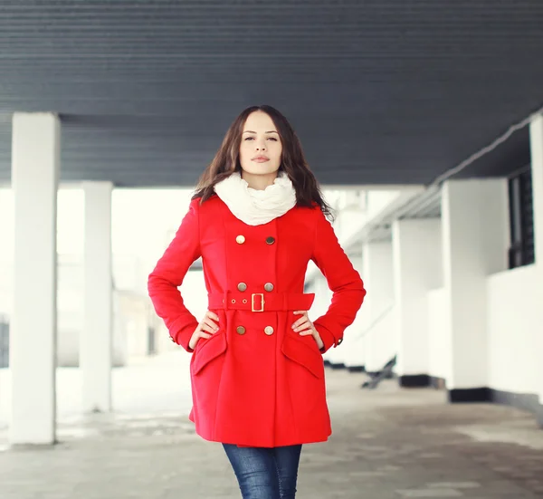 Portrait of pretty young woman dressed a red coat outdoors in th — Stock Photo, Image