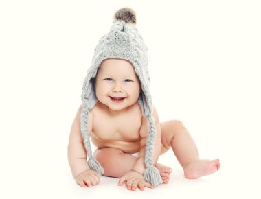 Sevimli gülümseyen bebek örgü şapkalı beyaz bir arka plan üzerinde oturan