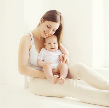 Mutlu genç anne ve beyaz oda n evde bebeği birlikte