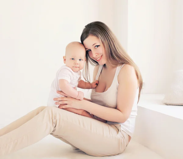 Young mother and baby at home in light room — Stock Photo, Image