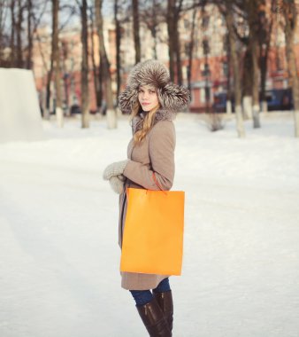 Güzel bir kadın açık havada yürüyüş ile sh bir ceket ve kürk şapka giymiş