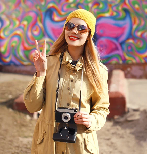 Портрет счастливой стильной девушки со старой ретро-камерой, веселящейся — стоковое фото