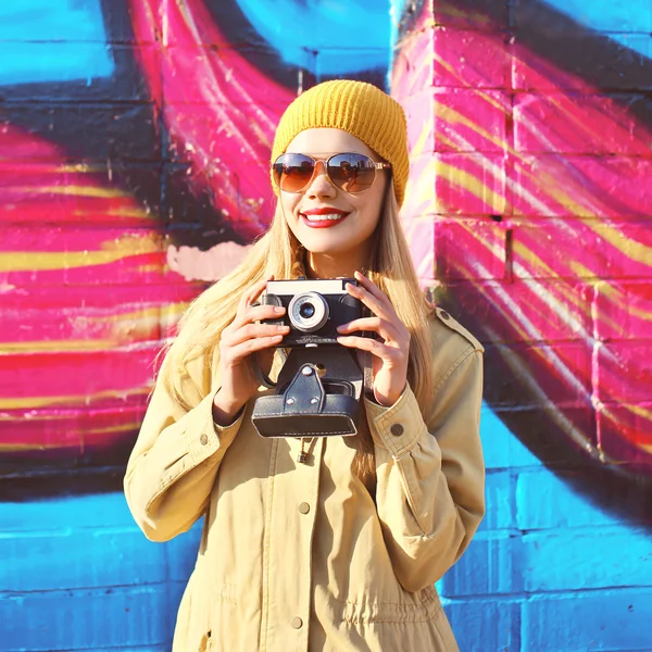 Портрет стильной улыбающейся девушки со старым ретро-фотоаппаратом. — стоковое фото