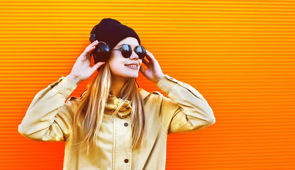 Retrato mulher bonita usando um chapéu preto e fones de ouvido escuta — Fotografia de Stock