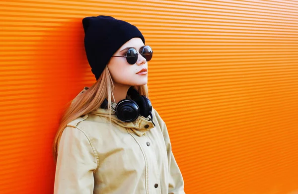 Güzel sarışın siyah bir şapka ve kulaklıklar giyen musi için dinler