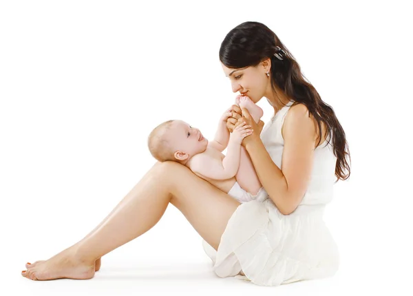 Happy loving  young mother kissing feet her baby — Stock Photo, Image