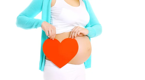 Gelukkig zwangere vrouw en grote rode hart in handen op een witte backg — Stockfoto