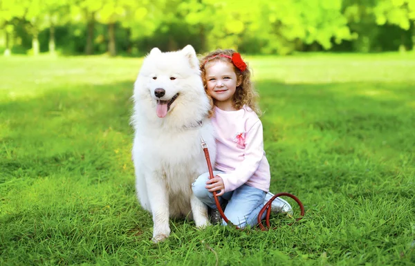 Retrato de niño con perro Samoyedo blanco en la hierba en s soleado —  Fotos de Stock