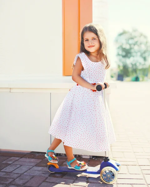 Retrato de menina na scooter se divertindo ao ar livre em su — Fotografia de Stock