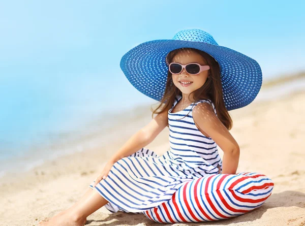 Çizgili elbise ve hasır şapka sevimli küçük kız portresi — Stok fotoğraf