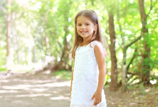 Porträtt av leende liten flicka promenader i skogen, soliga summan — Stockfoto