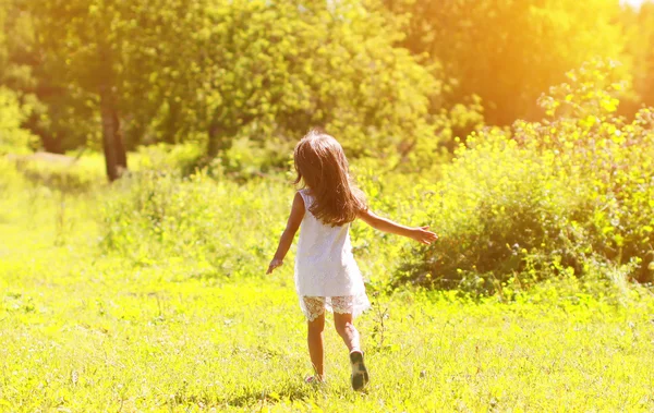 Silhueta de uma menina correr no campo em um verão ensolarado d — Fotografia de Stock