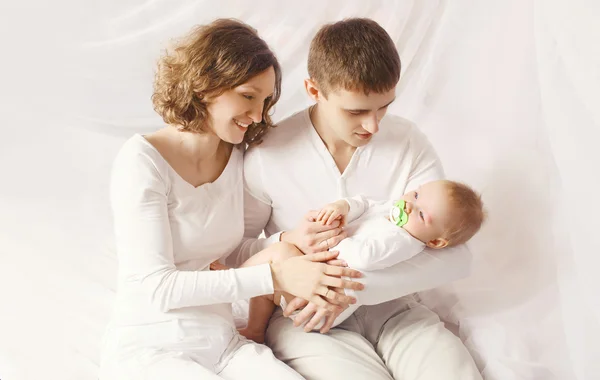 Portrait of happy family, young parents with baby at home on the — Stock Photo, Image