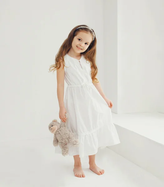 Oyuncak ayı evde beyaz oda ile sevimli küçük kız — Stok fotoğraf