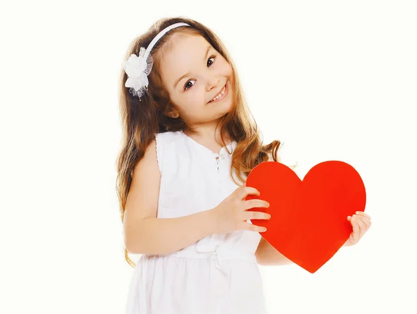 Joyeux petite fille avec grand coeur en papier rouge sur un fond blanc — Photo