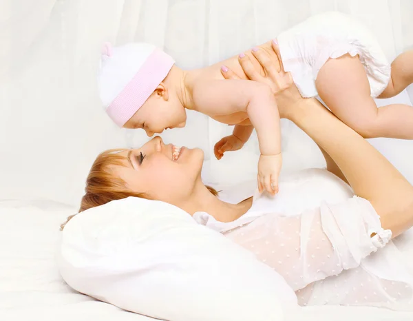 Mãe feliz e bebê se divertindo em casa na cama — Fotografia de Stock