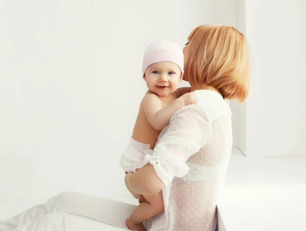 Retrato de madre feliz y bebé en casa juntos en habitación blanca —  Fotos de Stock