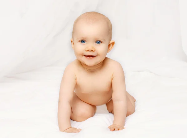 Retrato de bebé sonriente se arrastra en la cama en casa —  Fotos de Stock