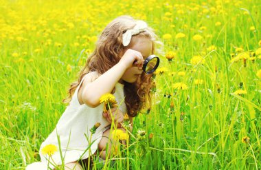 Büyüteç camı sarı d bakarak küçük kız çocuğu