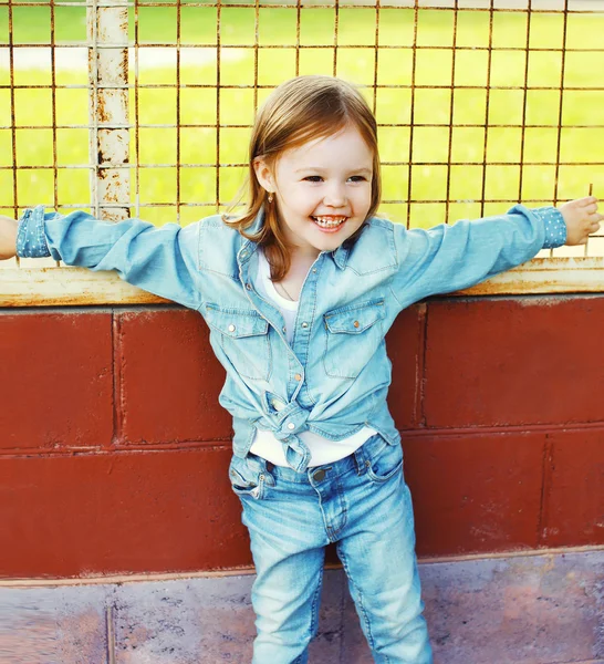 Портрет усміхненої маленької дівчинки-дитини в одязі на відкритому повітрі — стокове фото