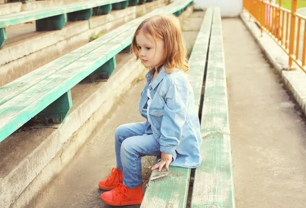 Şık küçük kız çocuk kot elbise sitti portresi — Stok fotoğraf