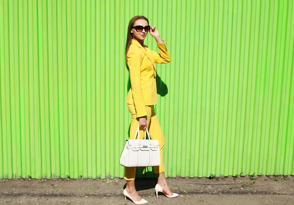 Мода элегантная молодая женщина в желтом костюме одежды с сумочкой — стоковое фото