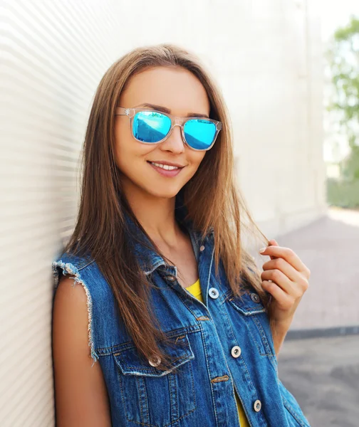 Outdoor fashion portrait of pretty girl in the sunglasses and je — Stock Photo, Image