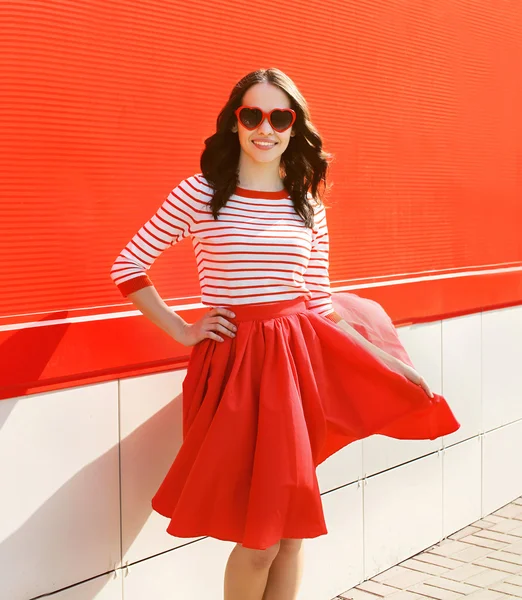 Mujer bonita en gafas de sol rojas y vestido contra el wa colorido —  Fotos de Stock